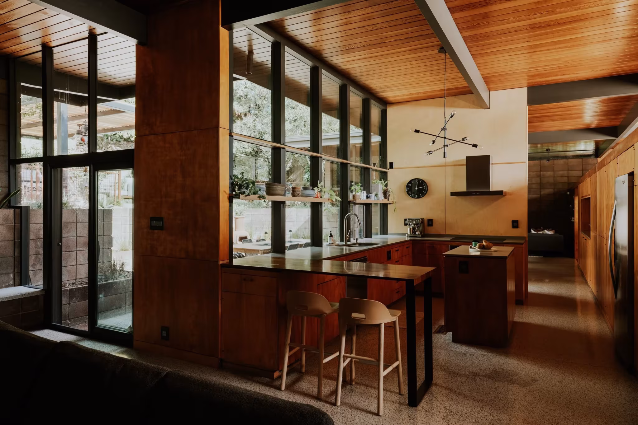 Cocina abierta de la Residencia Nittler con península de madera y ventanal hacia el exterior