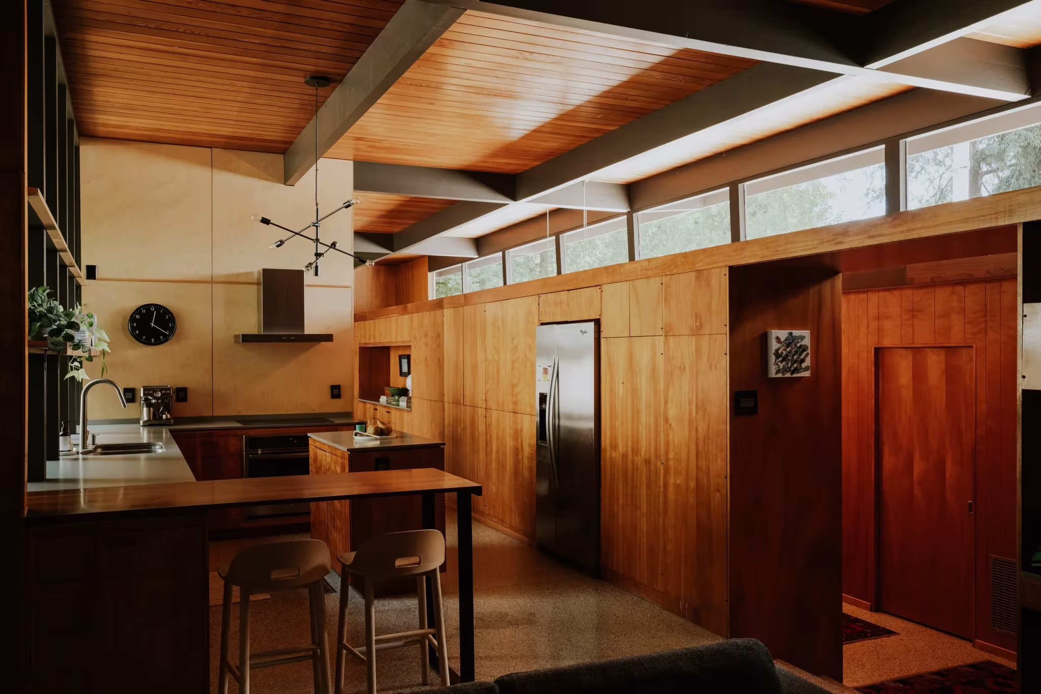 Cocina y despensa de la Residencia Nittler bajo el techo de madera con ventanas corridas altas
