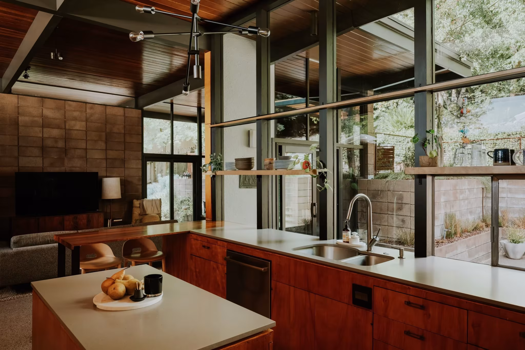 Cocina de la Residencia Nittler con isla de encimera clara y armarios de madera frente a la cristalera