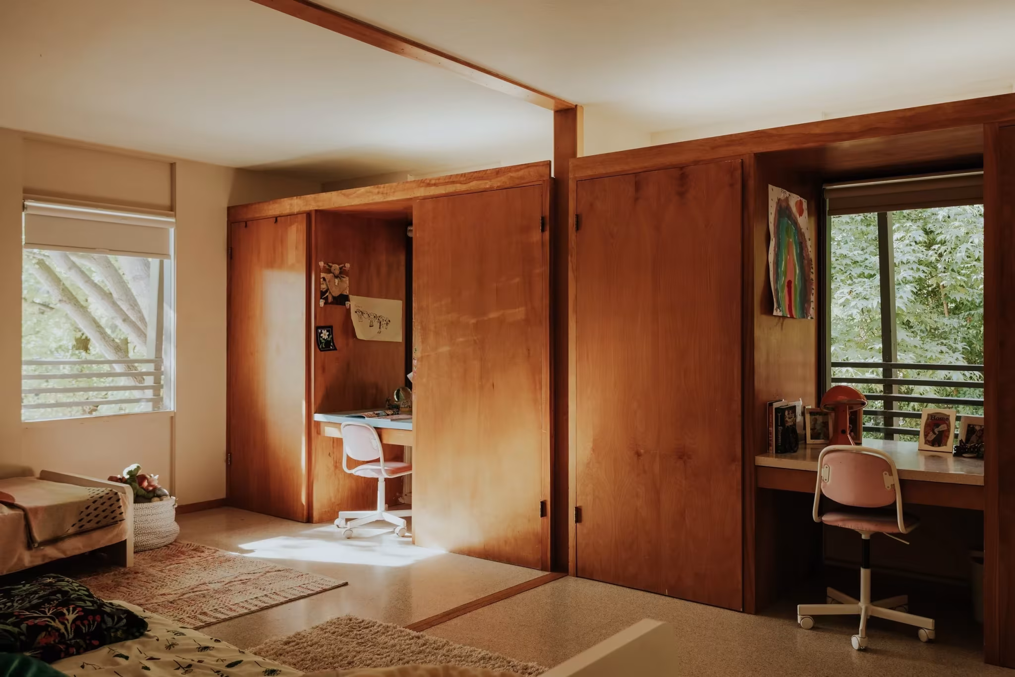 Dormitorio infantil de la Residencia Nittler con escritorio, panel corredizo de madera y ventana al jardín