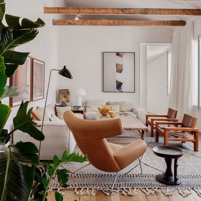 Salón de la Reforma Integral San Mateo de ÁBATON con vigas de madera, butaca de cuero y sofá blanco