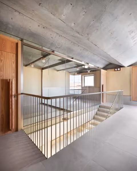Vestíbulo superior con forjado de hormigón visto, escalera y barandilla de varillas en la Casa Consistorial de Valverde de Campos