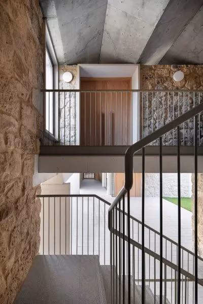 Escalera de barandilla metálica junto al muro de piedra en la Casa Consistorial de Valverde de Campos