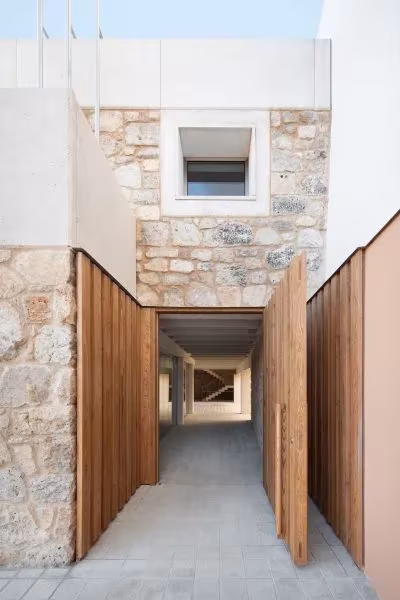 Acceso de la Casa Consistorial de Valverde de Campos entre dos hojas de madera, con muro de piedra y ventana alta