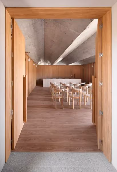 Sala de reuniones de la Casa Consistorial de Valverde de Campos con sillas de madera bajo un techo de hormigón