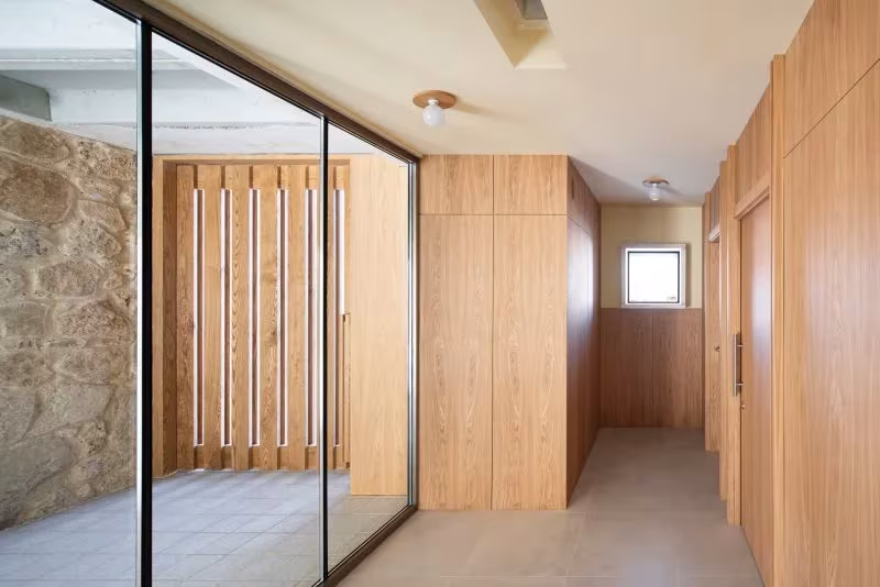 Sala acristalada con muro de piedra y paneles de madera de roble en la Casa Consistorial de Valverde de Campos