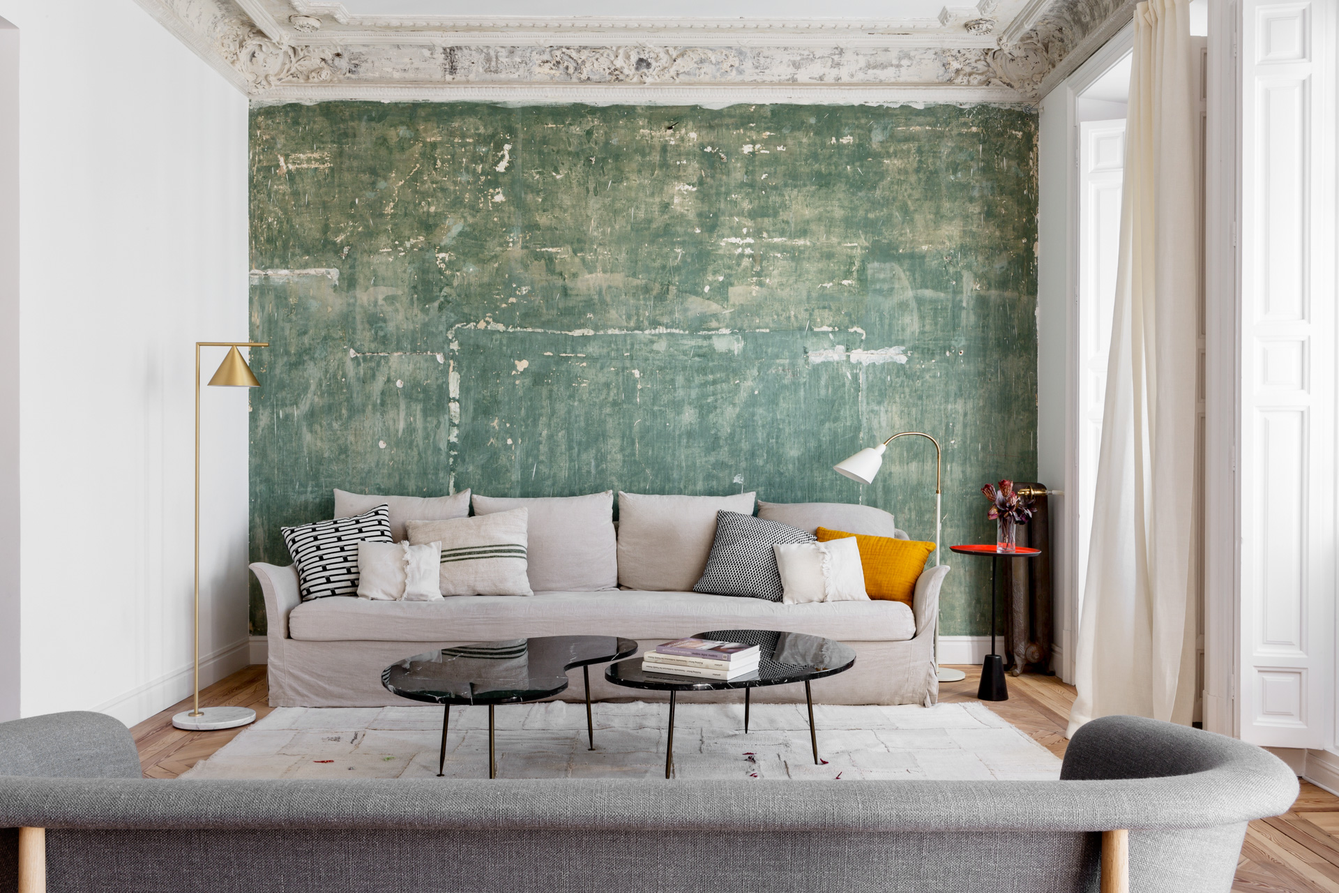 ABATON-reforma-integral-en-sagasta-23 Salón con dos sofás grises de diferentes estilo, techo con molduras decorativas, pared verde desgastada y decoración contemporánea minimalista