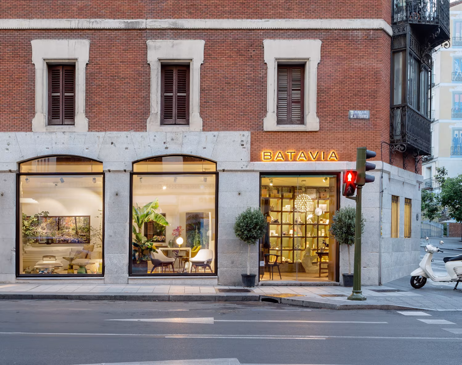 Brick and stone corner with the Batavia shop windows in Madrid, a project by Ábaton