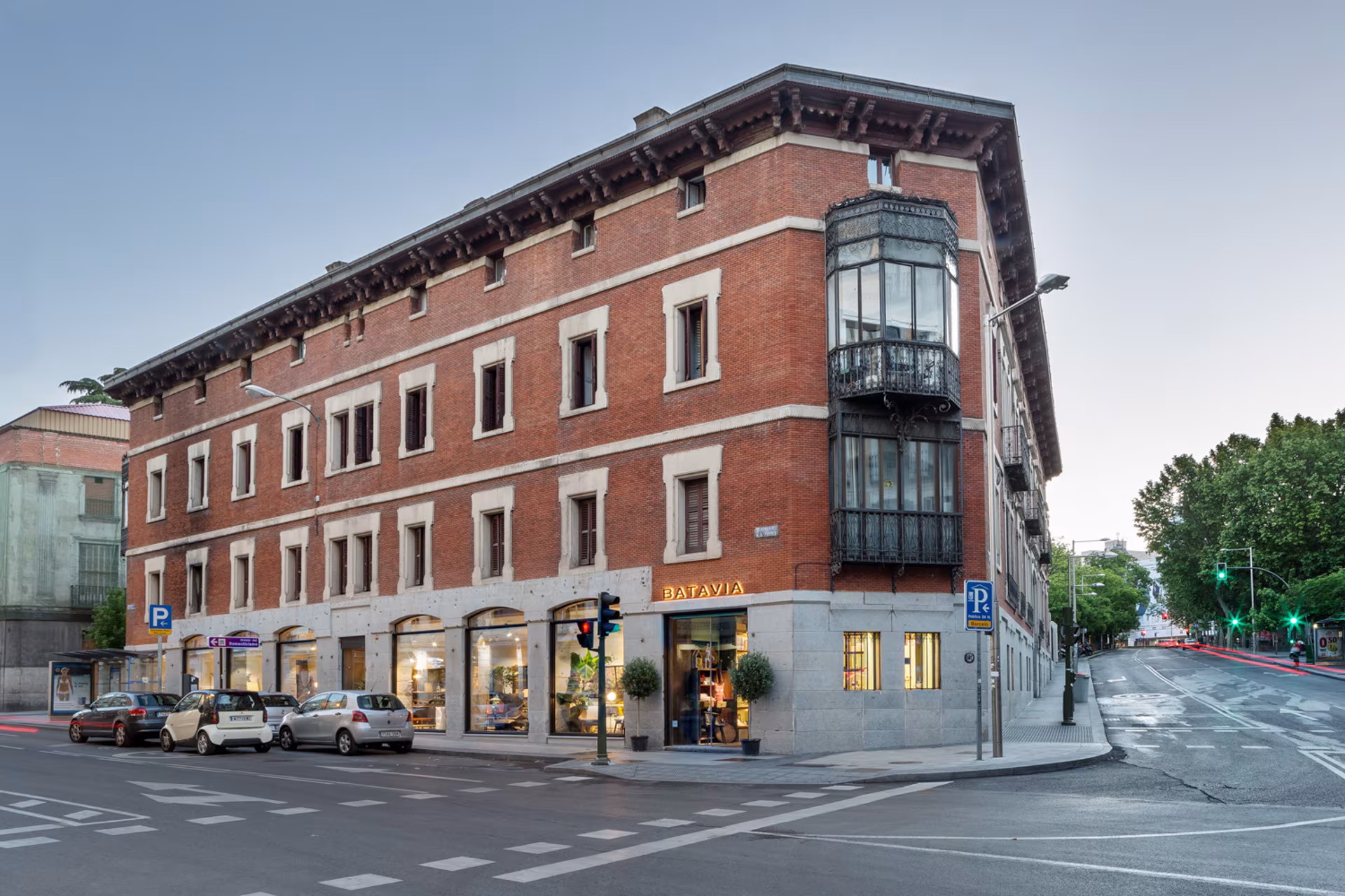 A brick corner building with bay windows and a stone ground floor, which houses the Batavia store in Madrid