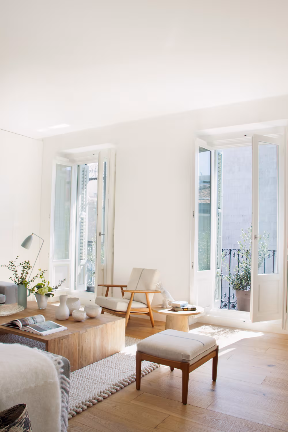 Living room of Casa Ayala II with French windows, natural light, timber armchairs and parquet in Madrid