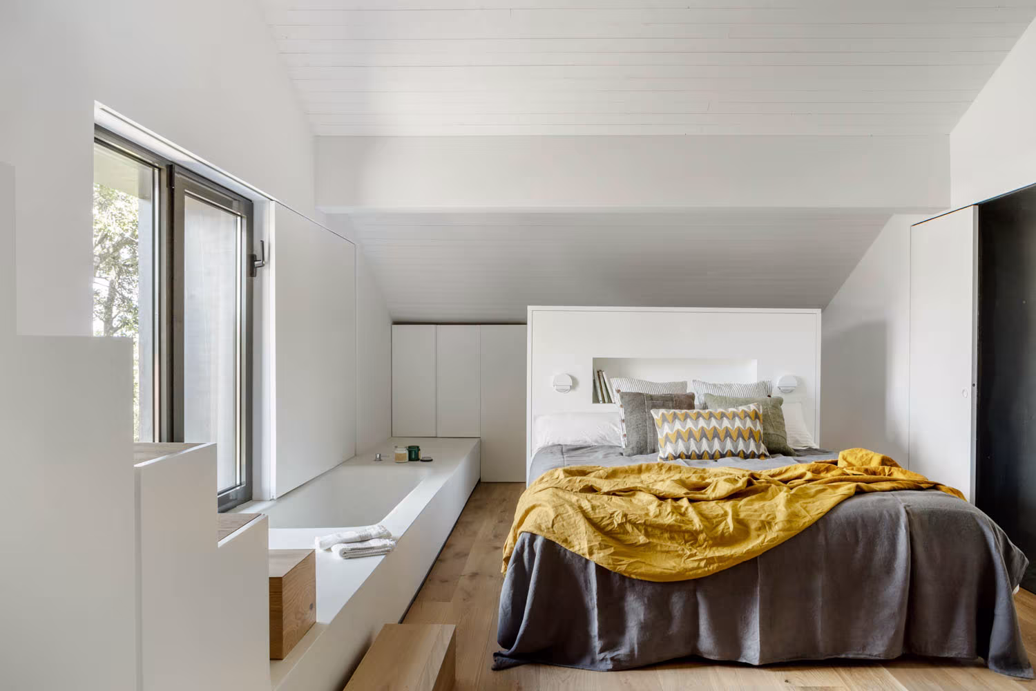 Dormitorio abuhardillado de Casa de Campo LS de Ábaton con bañera junto a la cama y ventanas al jardín