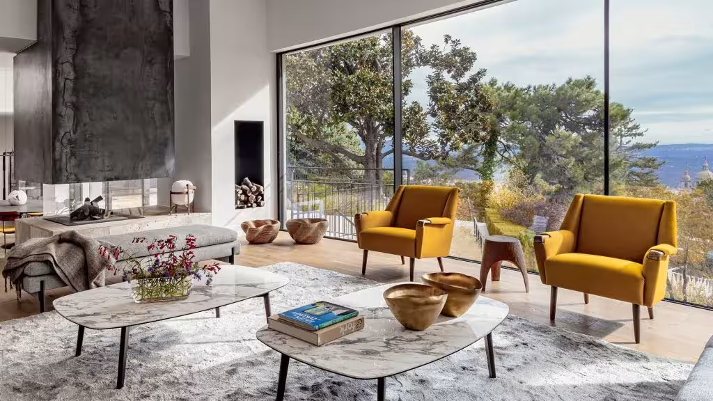 Salón de casa reformada con grandes ventanales con estilo moderno y acogedor.
