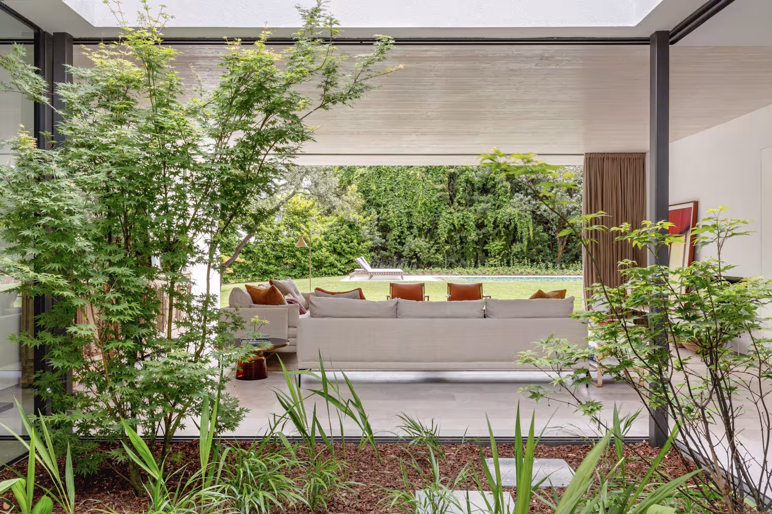 Inner courtyard with maples and planting seen from the house, living room and garden beyond, LVL refurbishment