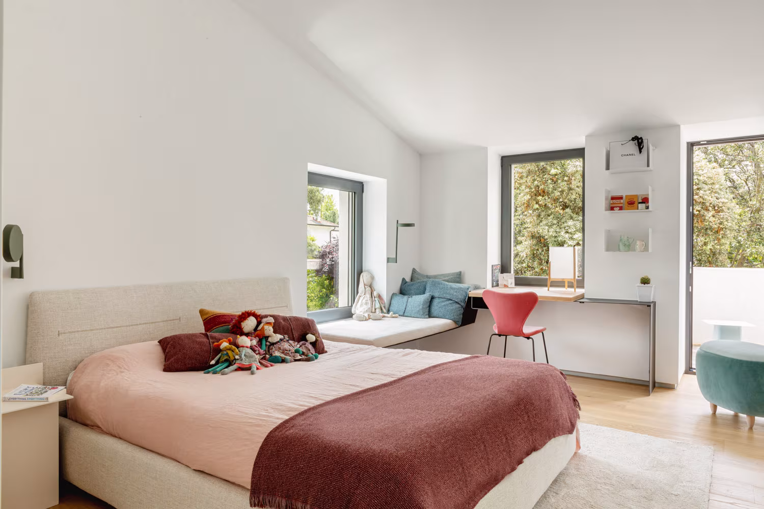 Bedroom with pitched ceiling, pink bedding and a window seat for reading, LVL refurbishment, Madrid
