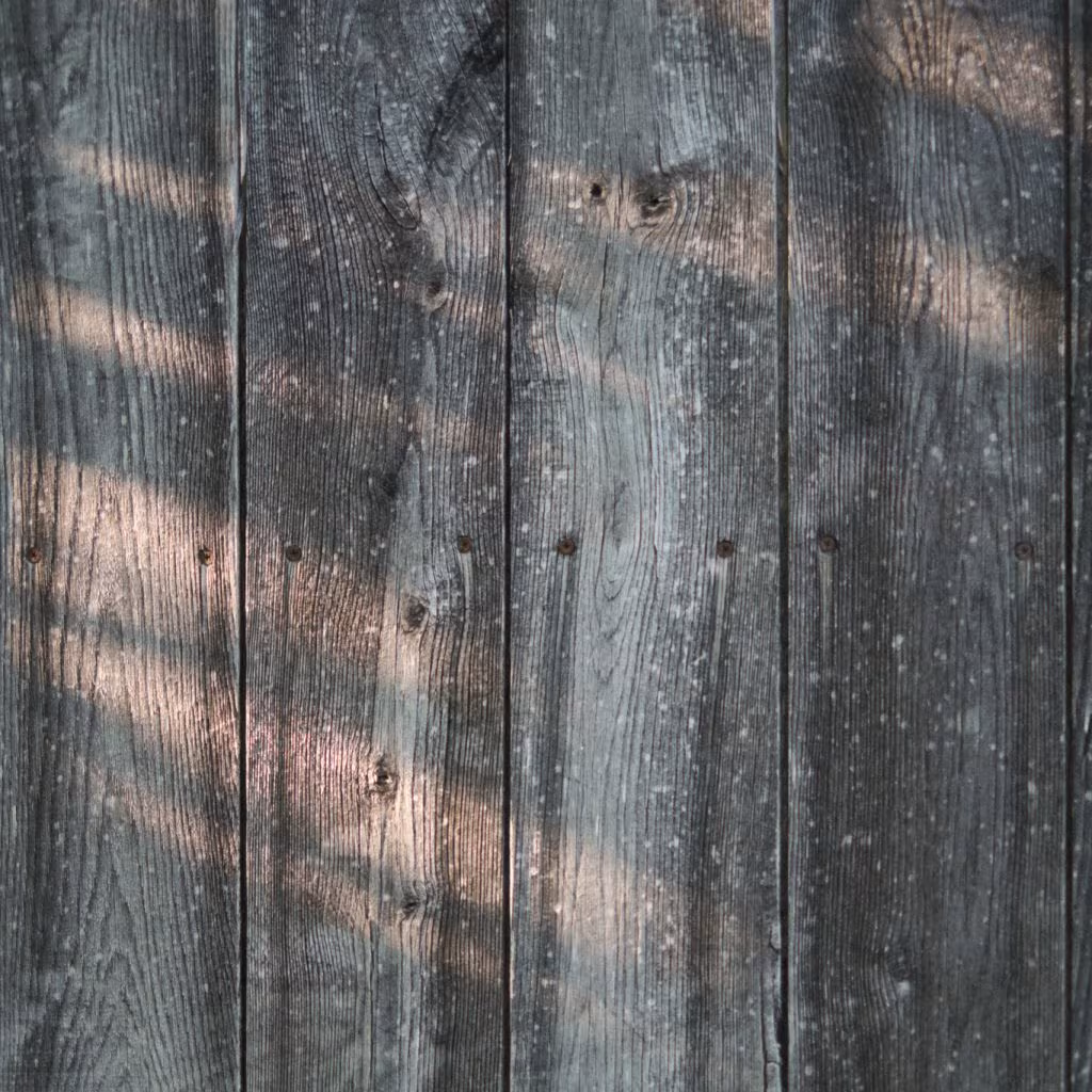 Texture of weathered wooden planks with shadows of leaves, inspiration for the ÁPH80 home