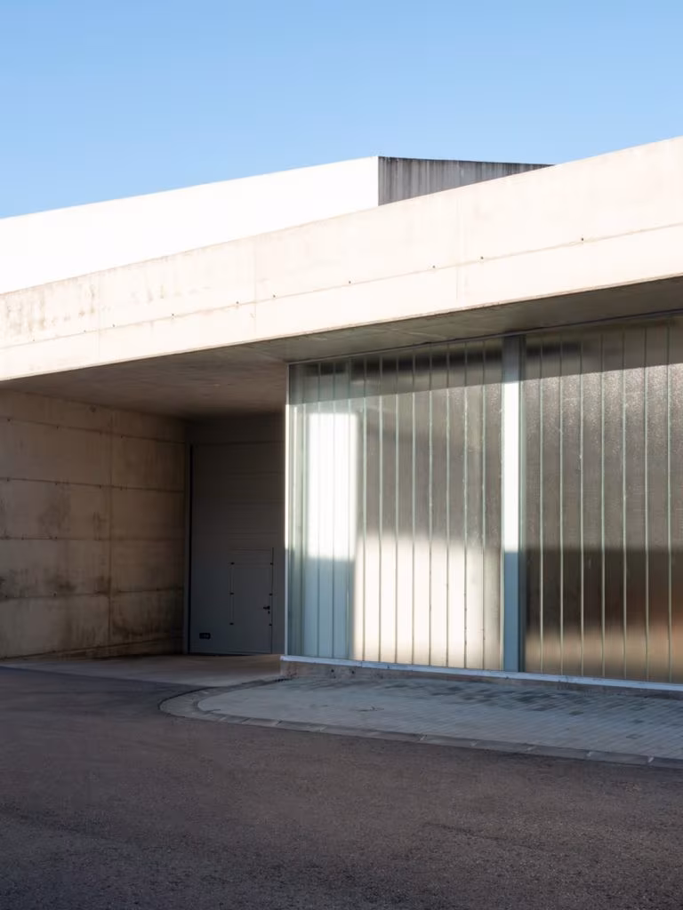 CVNE concrete building with a ribbed translucent glass panel and a canopy over the lorry access