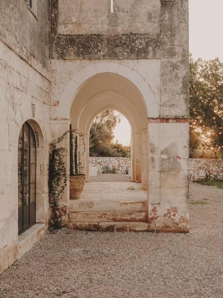 Arco de piedra de un pórtico abierto a la luz del atardecer en la Casa Casolare Scarani de Andrew Trotter