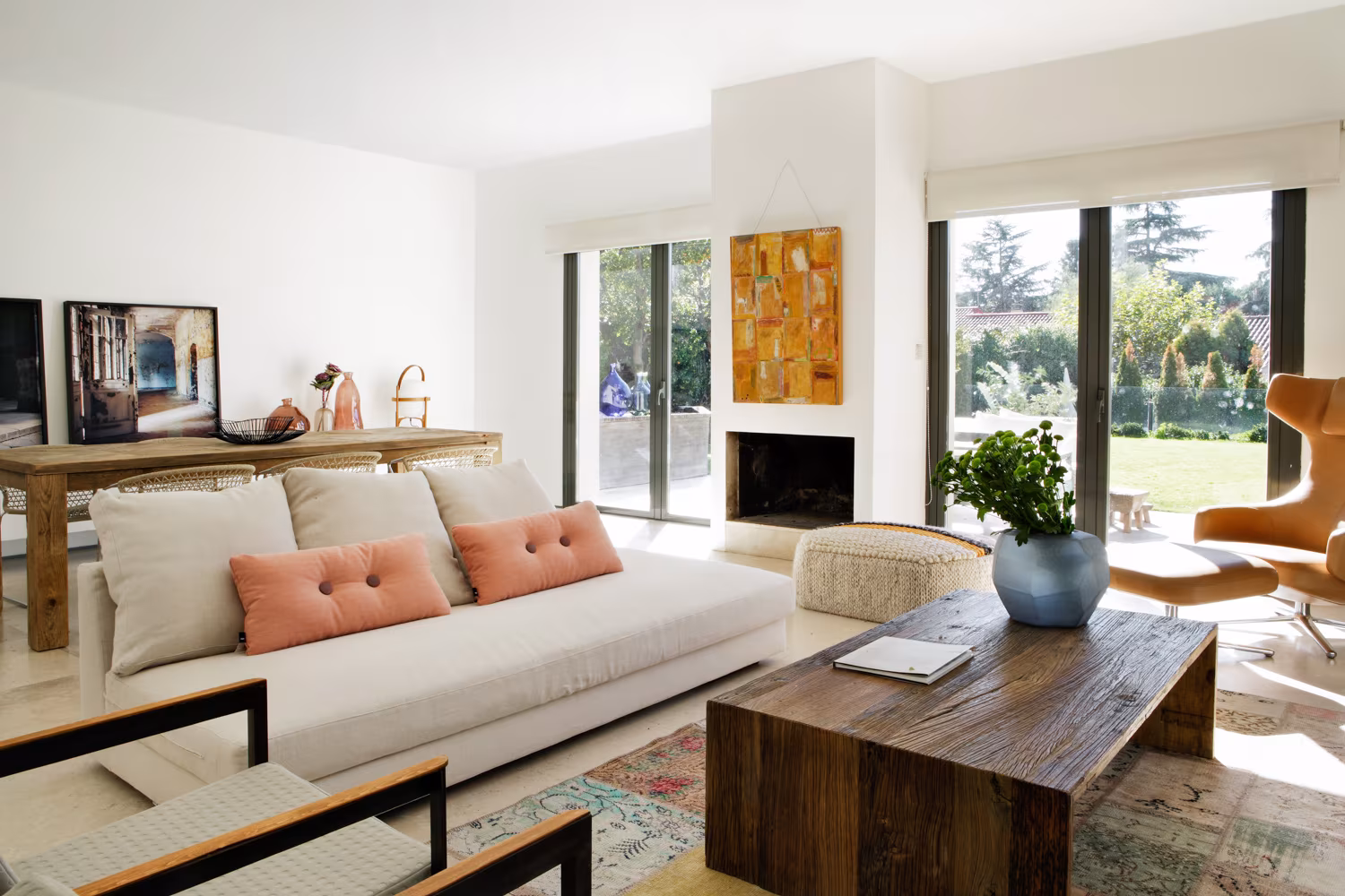 Living room with pale sofa, pink cushions, solid timber table and window onto the lawn, Casa Oviedo
