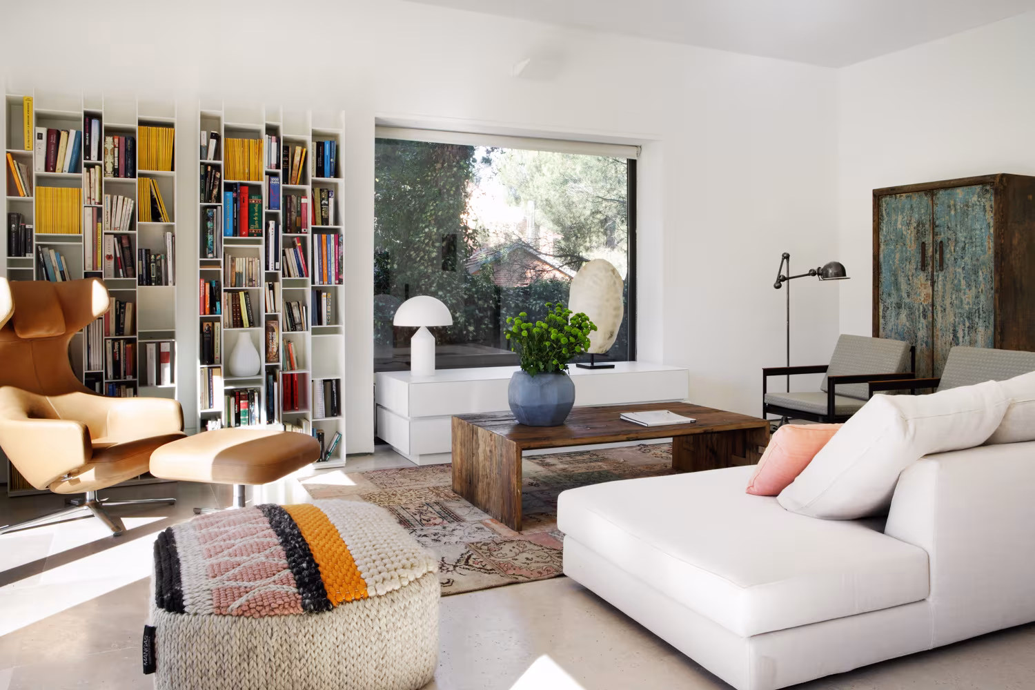 Living room with white chaise longue, patterned pouffe, bookcases and antique blue cabinet, Casa Oviedo by Ábaton