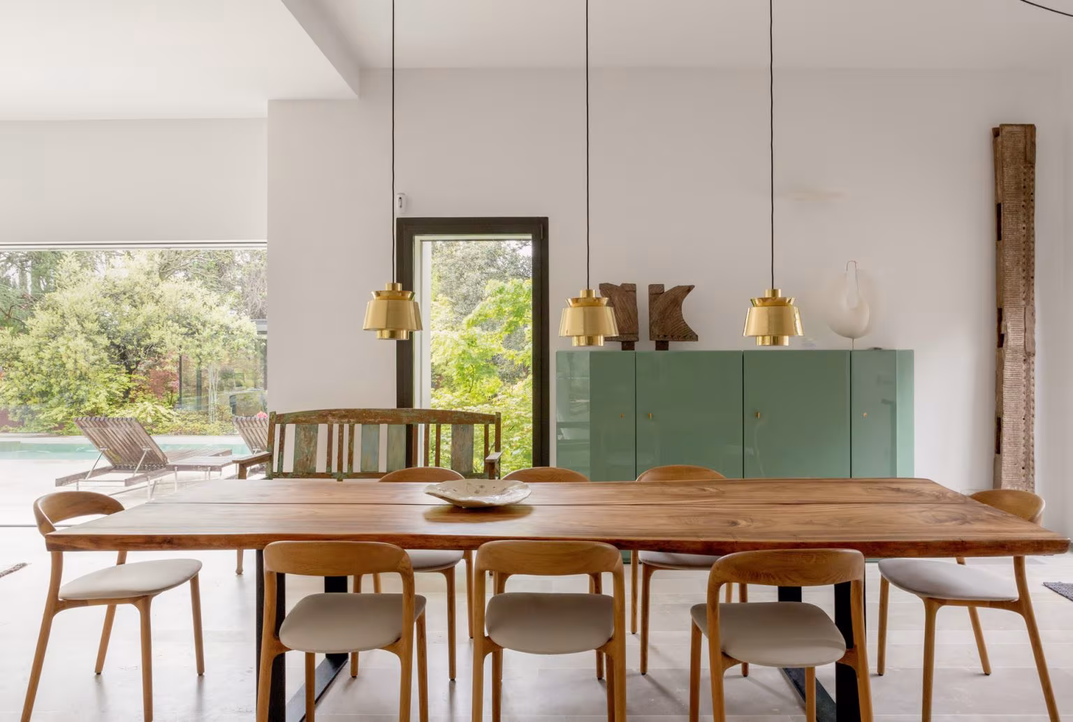 Meeting room with long timber table, oak chairs and green sideboard facing the pool, Ábaton studio