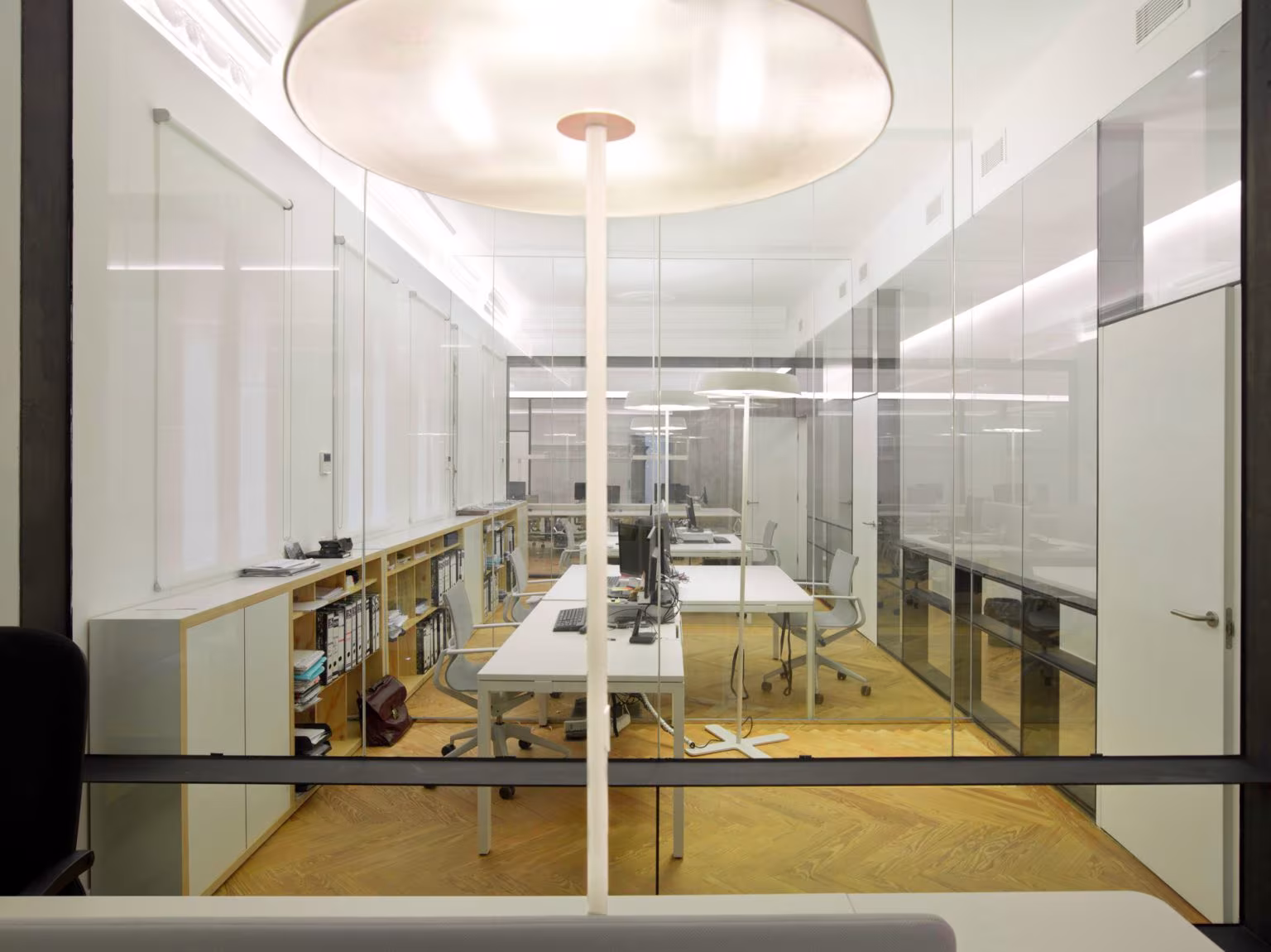 Open-plan office with glass partitions, long white desks and a circular lamp, Oficina ED, Madrid