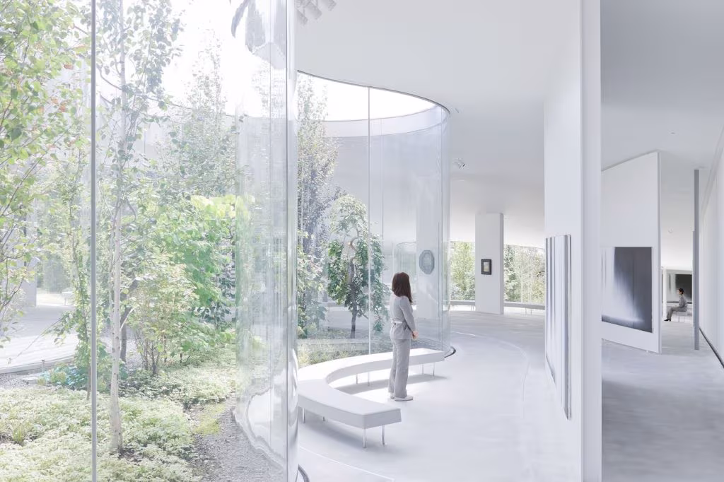 Circular exhibition room of curved glass opening onto a tree-filled garden at the Hiroshi Senju Museum