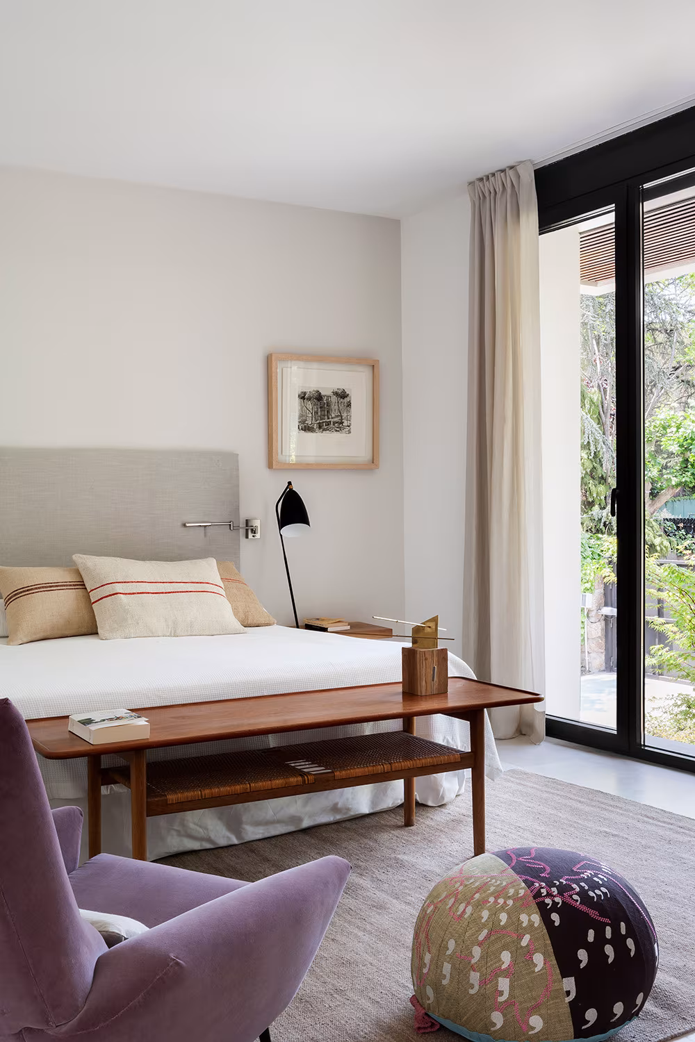 La Moraleja-ABATON-2 Bedroom with white bed, timber bench and mauve armchair before curtained glazing, La Moraleja