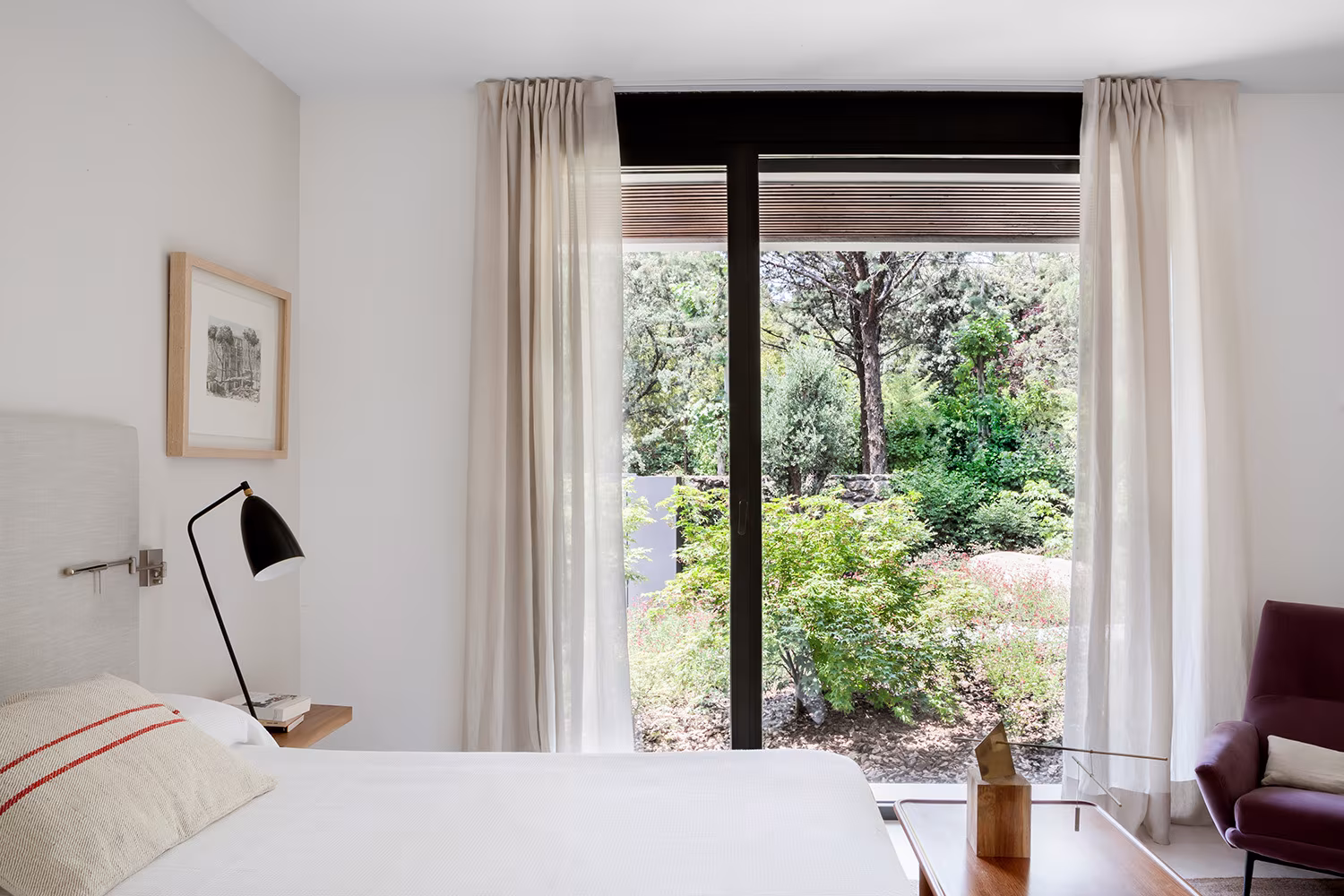 La Moraleja-ABATON-6 Bedroom with large window onto a planted garden, linen curtains and black reading lamp, La Moraleja refurbishment
