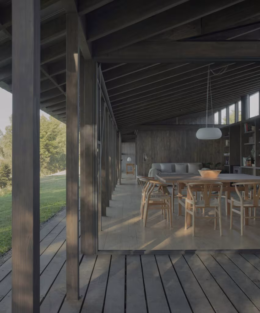 Galería de madera con suelo de tarima ante el comedor de Casa Puerto Nuevo, abierta al paisaje