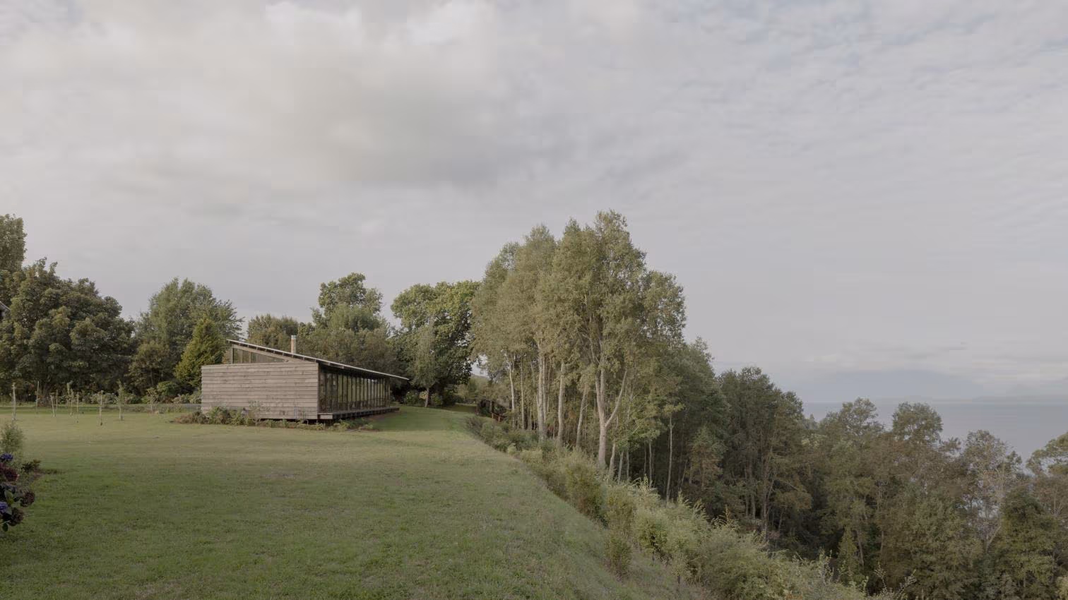 Casa Puerto Nuevo en el borde de un prado sobre el lago, rodeada de arbolado