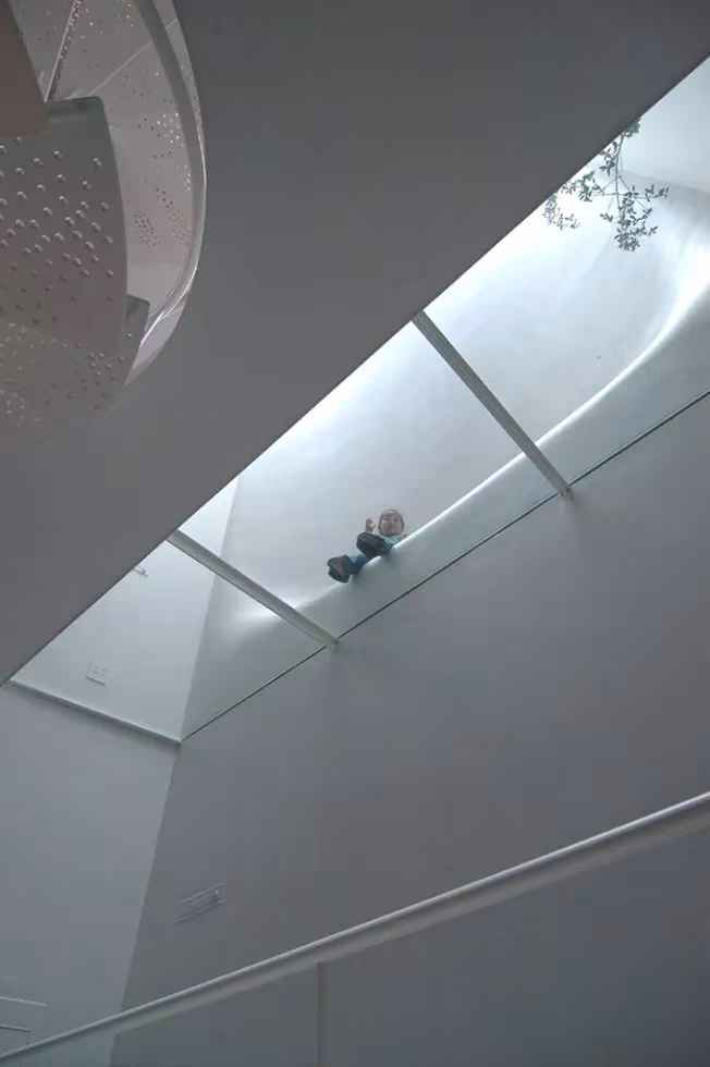 Lucernario inclinado con claraboyas sobre la escalera de la House SH de Hiroshi Nakamura, visto en escorzo