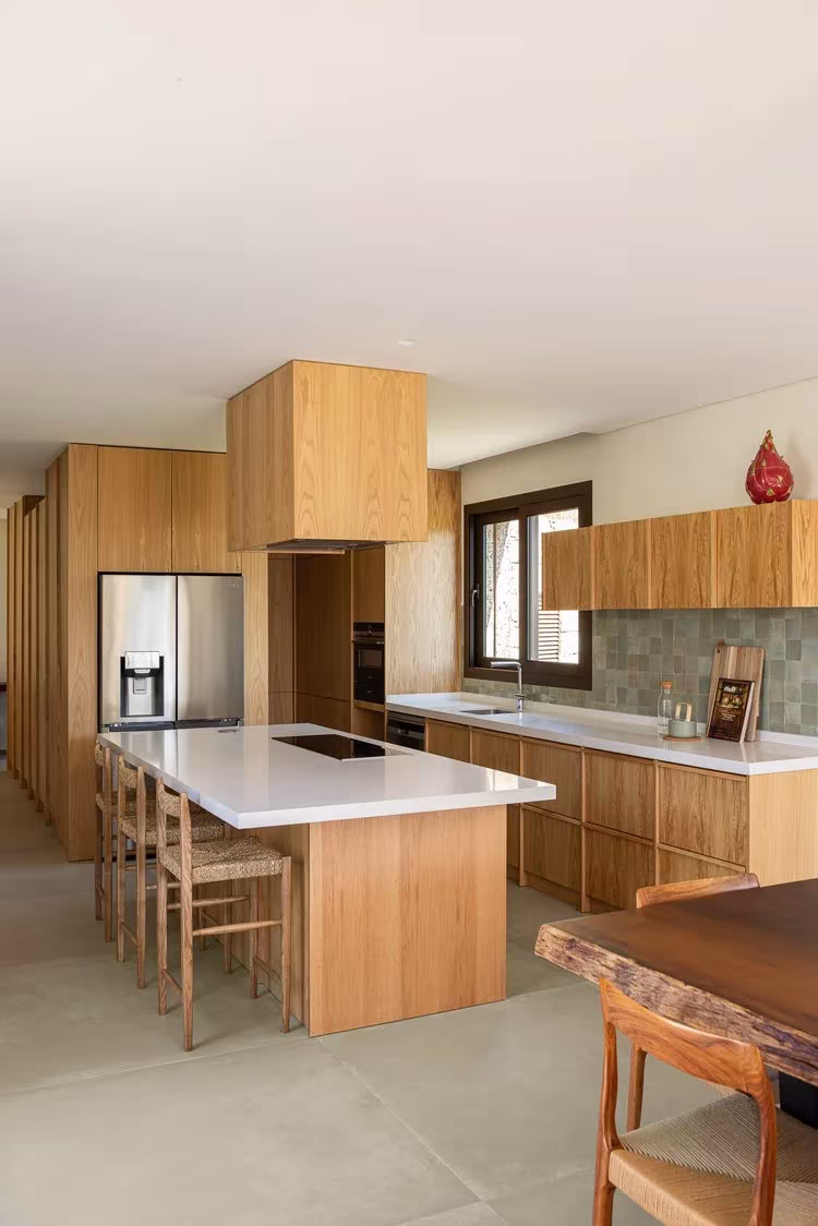 Cocina de la Casa da Levada de roble y encimera blanca, con mesa de madera de canto vivo