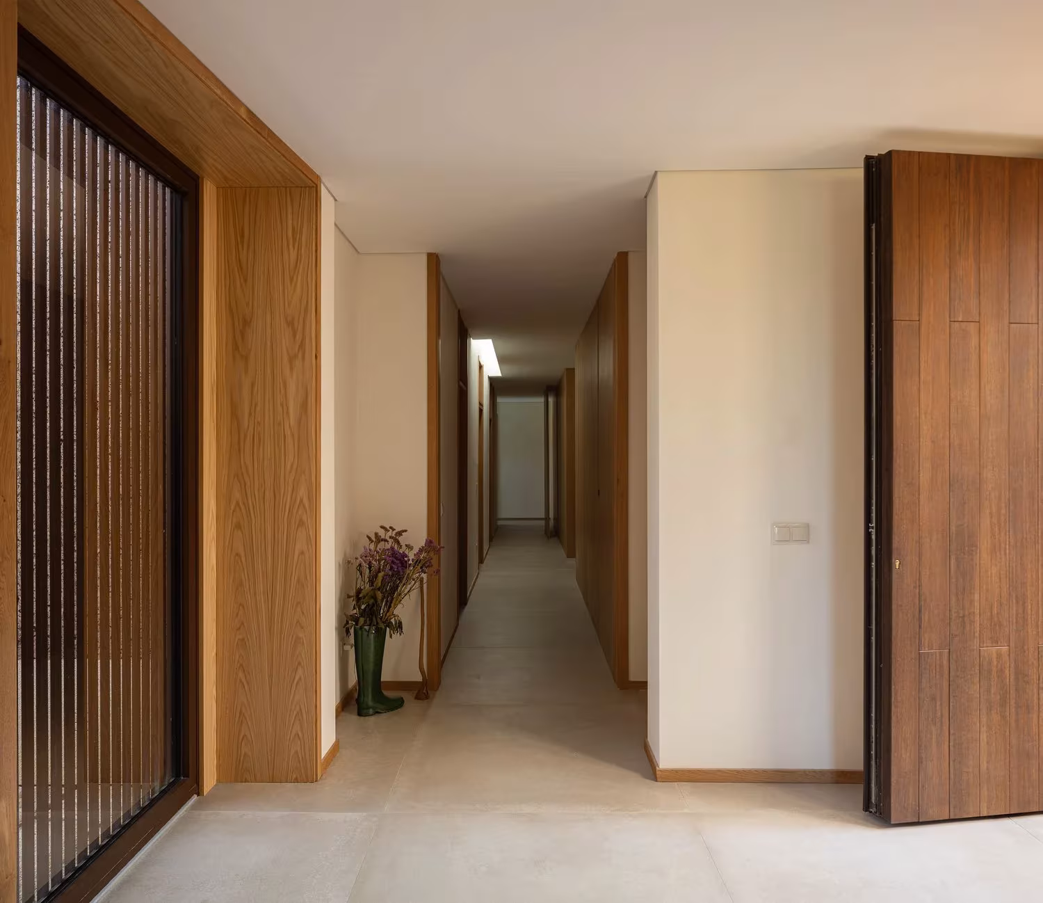 Galería interior de la Casa da Levada con celosía de madera junto a un pasillo que lleva a los dormitorios