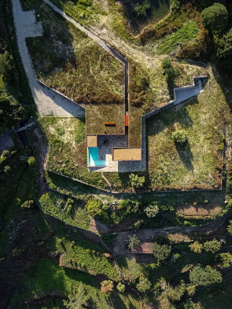 Vista cenital de la Casa da Levada con cubierta ajardinada, piscina y bancales de la ladera