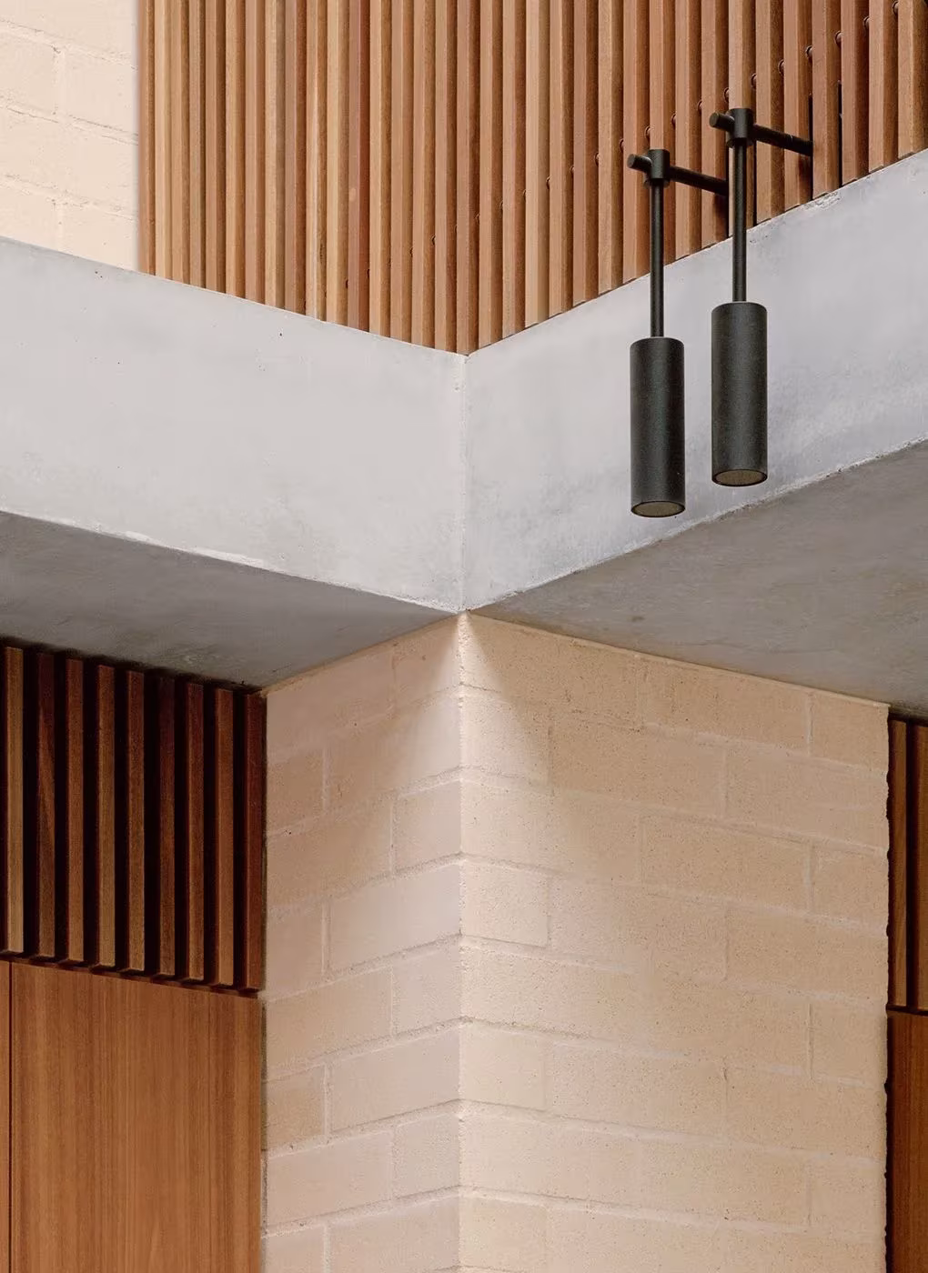 Encuentro de forjado de hormigón, ladrillo claro y listones de madera con luminarias colgantes en la Bronte House