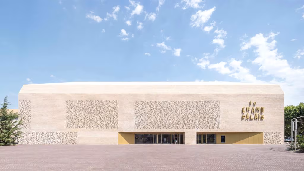 Fachada de ladrillo claro del cine Le Grand Palais en Cahors, de volumen bajo y cubierta a dos aguas