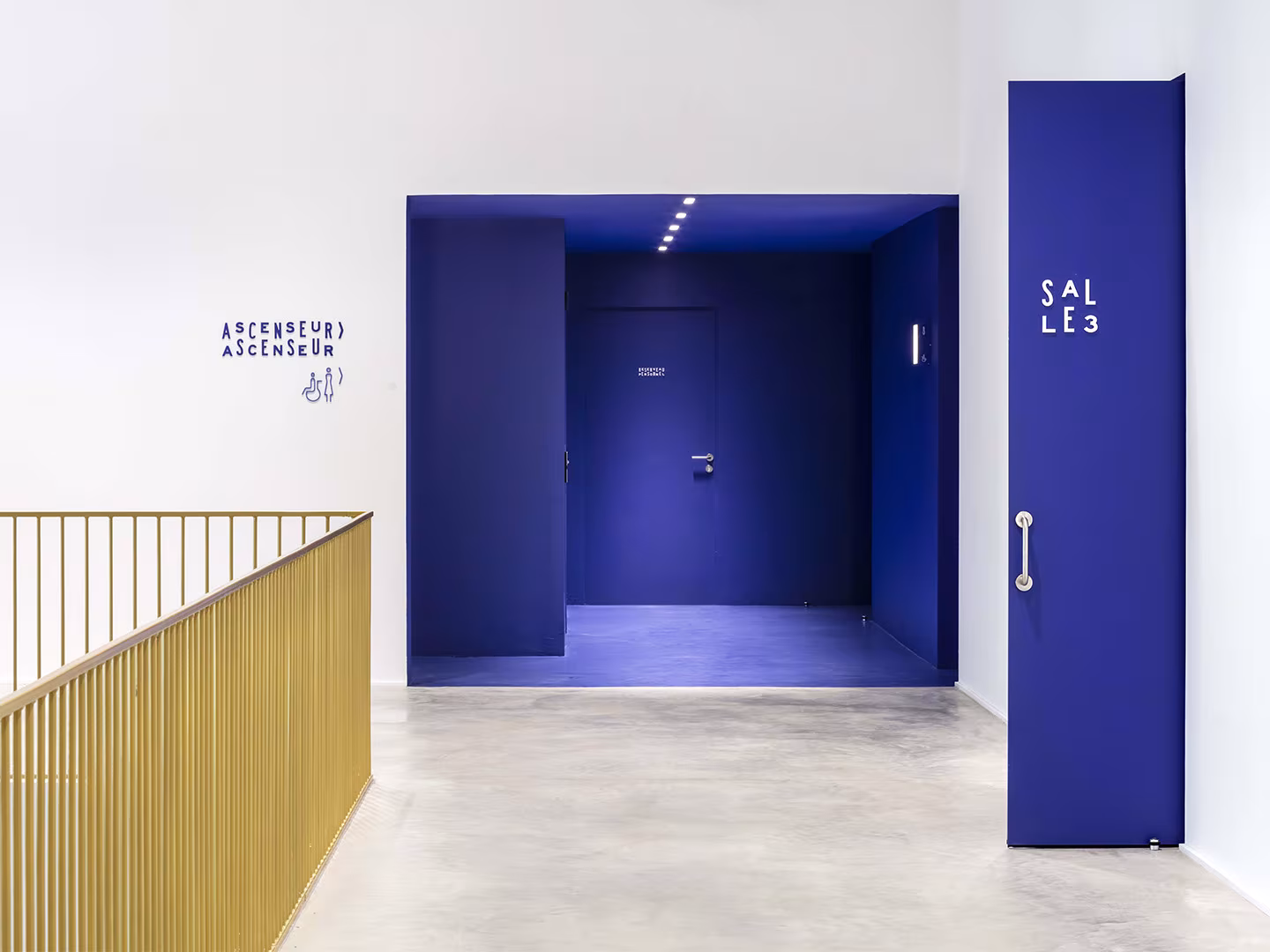 White foyer of Le Grand Palais with a cobalt blue recess and the door to the screening rooms