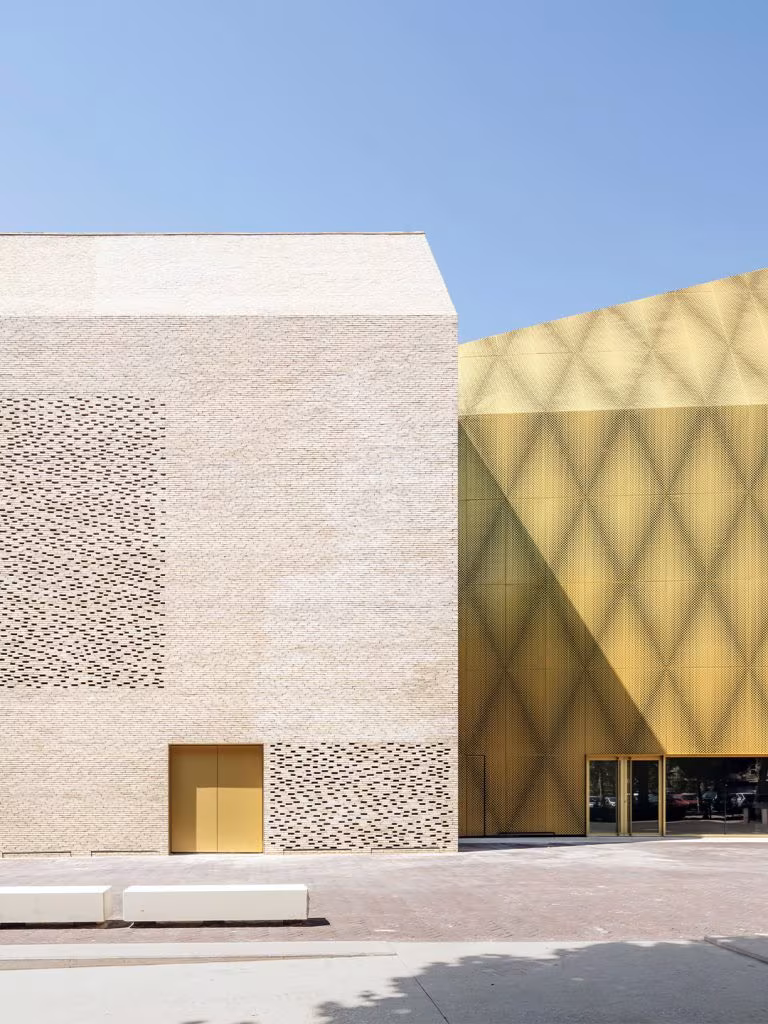 Le Grand Palais in Cahors with perforated brick and a golden volume of diamond-pattern panels