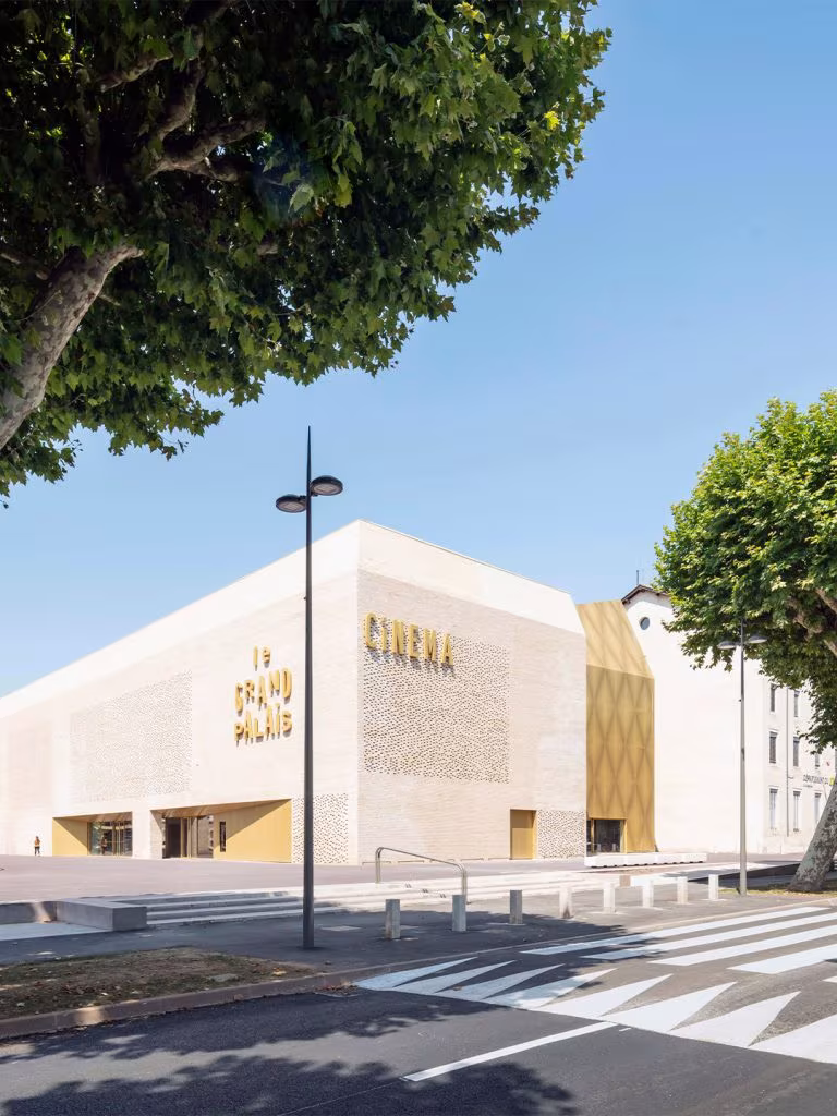 Le Grand Palais in Cahors seen from the street, with its pale brick volume and golden front