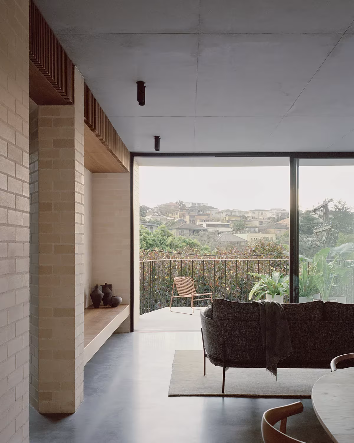 Salón de la Bronte House con banco empotrado de madera y ventanal corredero que mira al barrio de Bronte