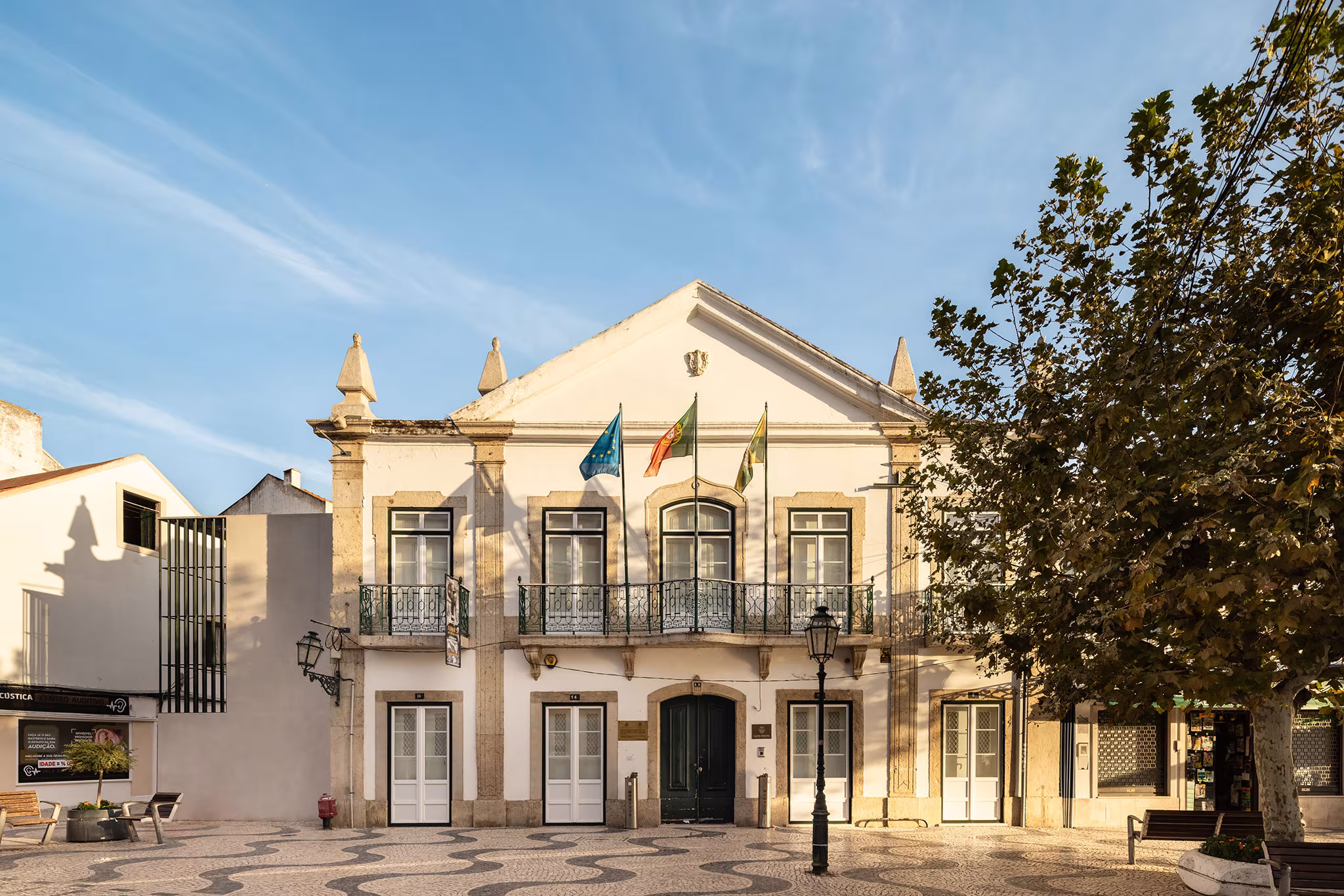 Edificio histórico de la Galería Municipal con fachada ornamentada y banderas, junto al Jardim da Galeria Municipal