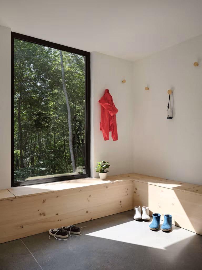 Entrance hall with a pine bench under a large window framing the forest, TISSARAOUATA