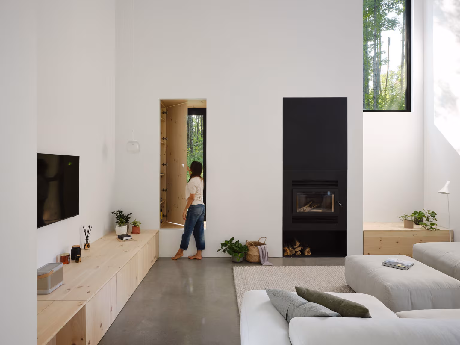 Sitting room with a black fireplace, low pine unit and pale sofa by the window, TISSARAOUATA