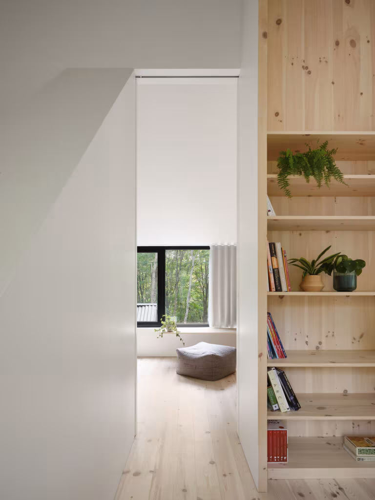 Hallway with pine shelving and a view of the sitting room lit by a black window, TISSARAOUATA