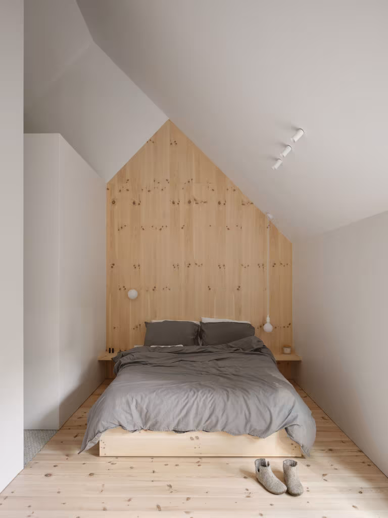 Bedroom with a pine headboard following the sloping roof and a low bed, TISSARAOUATA