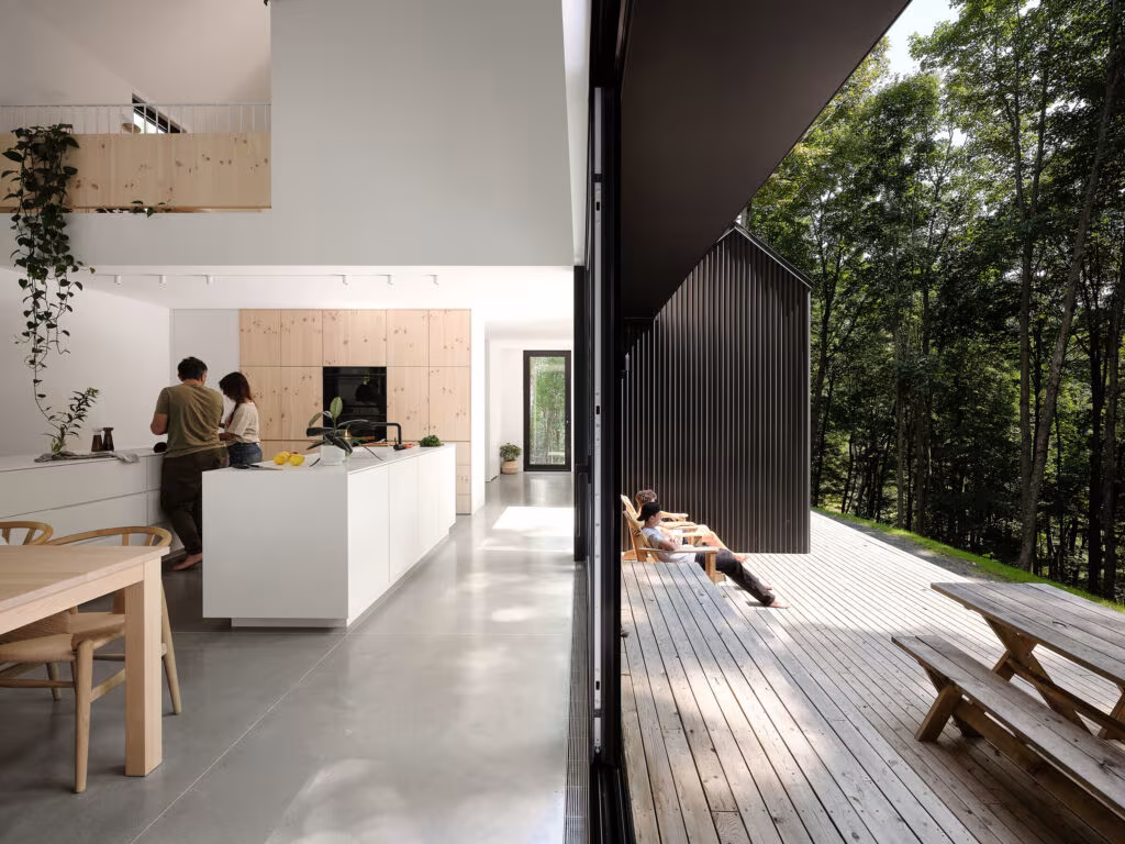 Cocina blanca con isla abierta a una terraza de madera entre árboles en TISSARAOUATA