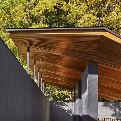 Cubierta quebrada de lamas de madera sostenida por pilares oscuros en el pabellón de Ueno Toshogu