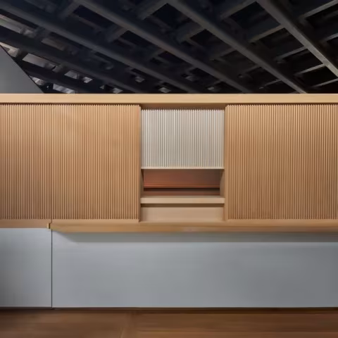 Mueble de madera con listones y mostrador del pabellón de Ueno Toshogu, bajo el techo oscuro de vigas