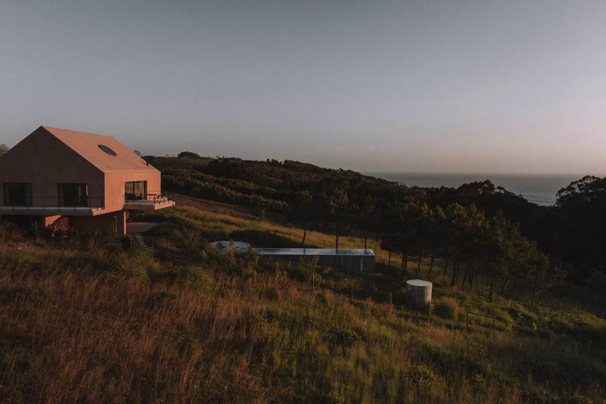 Casa Plaj on the hillside beside the pool, with the scrub and sea beyond