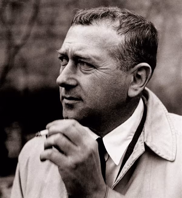 Sepia portrait of Marcel Breuer with a cigarette and a light trench coat